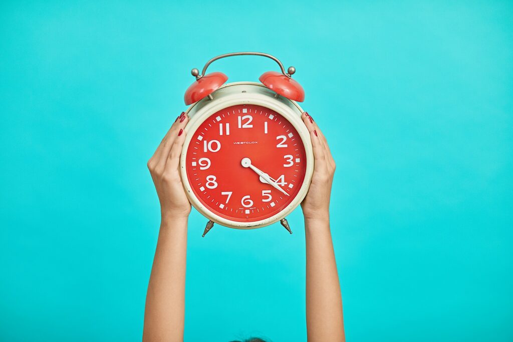 two hands holding a clock